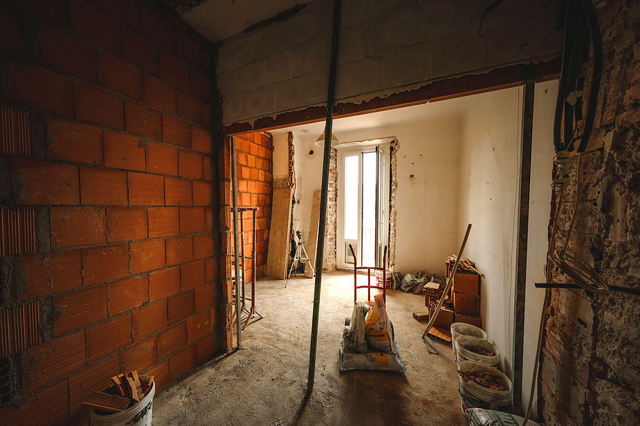 Ruwbouw van een woning: bakstenen wanden met een nieuwe doorbraak naar de aangrenzende ruimte